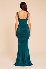 Teal green evening maxi gown on a beige background