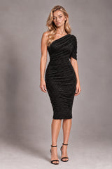 A woman modeling a black one-shoulder ruched midi dress with a short sleeve, paired with black high-heeled sandals, against a neutral gray studio background.