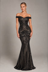 A woman modeling an off-the-shoulder black evening gown with intricate beaded and sequined patterns, photographed against a neutral gray studio background.