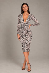 A woman modeling a long-sleeve bodycon dress with a black, gray, and white animal print pattern, featuring a deep V-neckline, on a solid gray studio background.