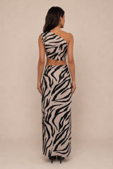 A woman shown from the back wearing a one-shoulder zebra-print maxi dress with a matching high-waisted crop top, set against a plain beige studio background.